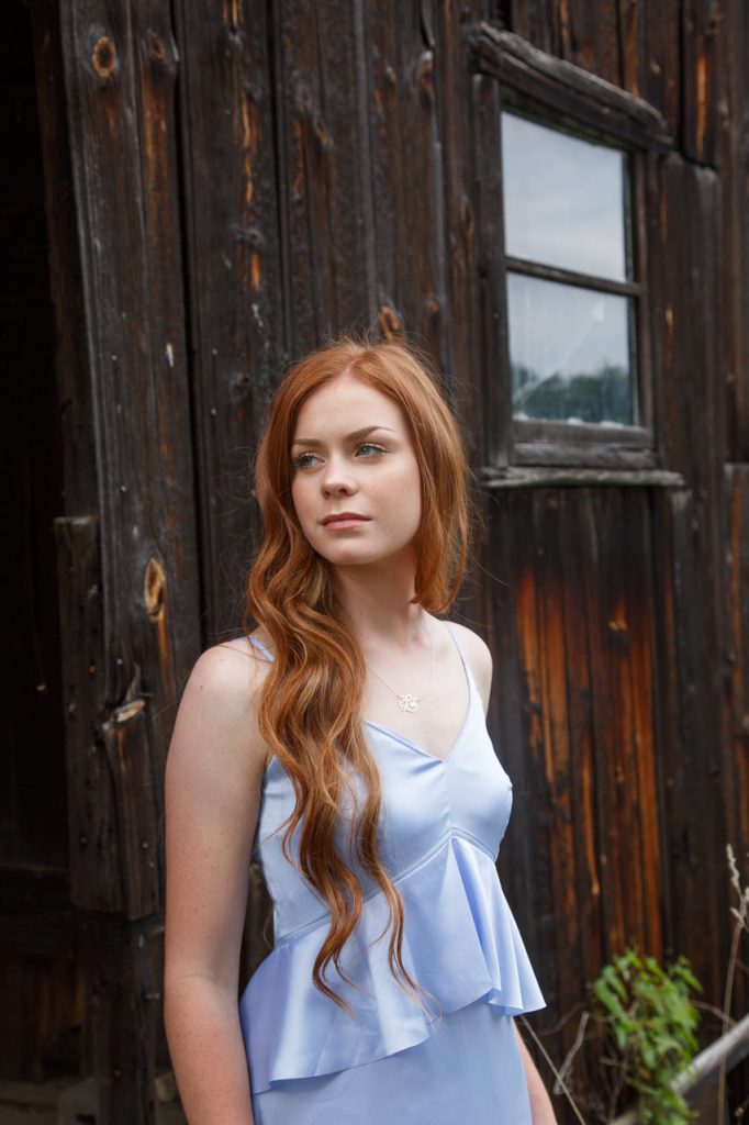 fall senior photo girl next to barn